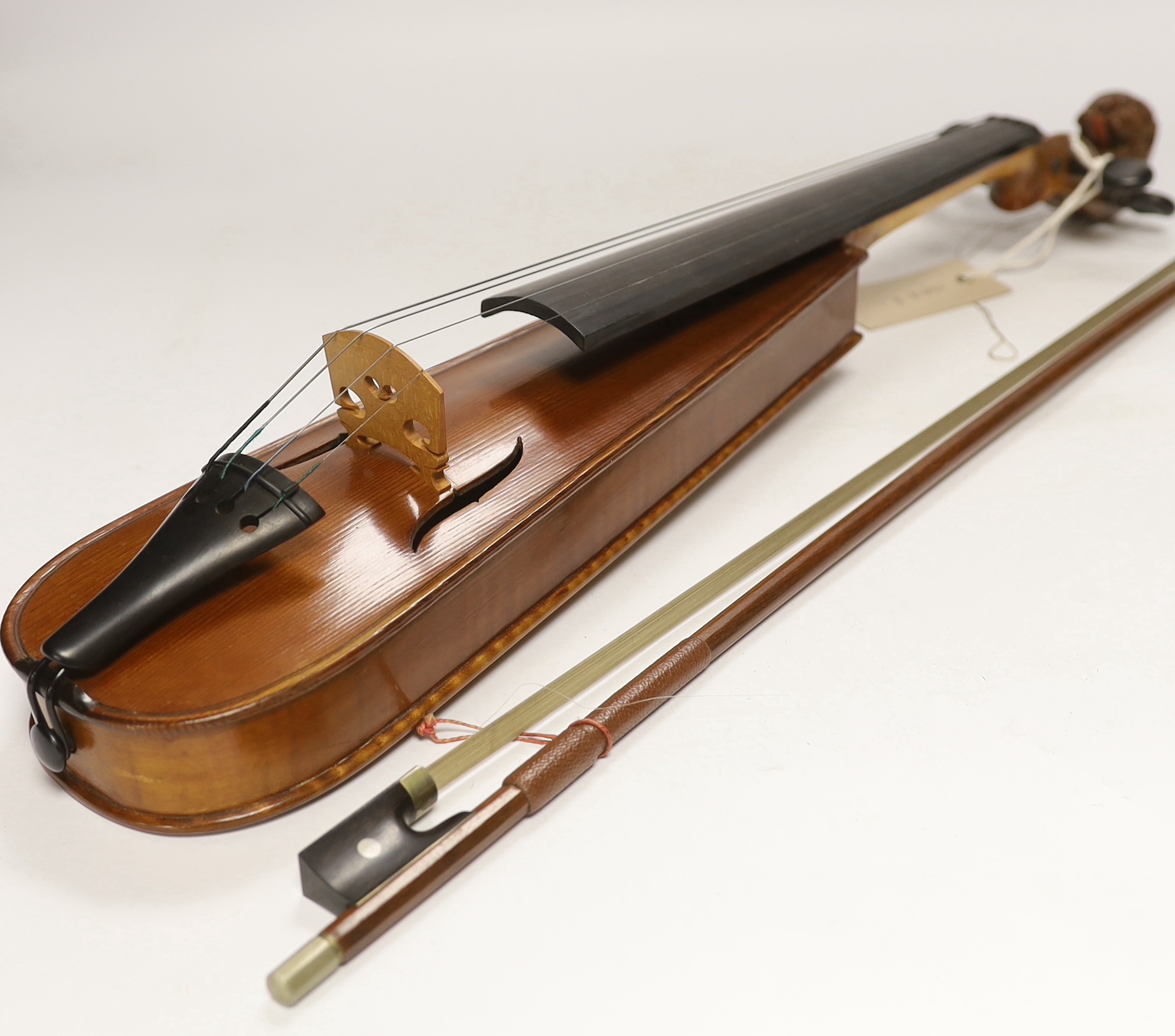 A 'travelling' violin and bow, the violin with grotesque head scroll carving, body 30.5cm